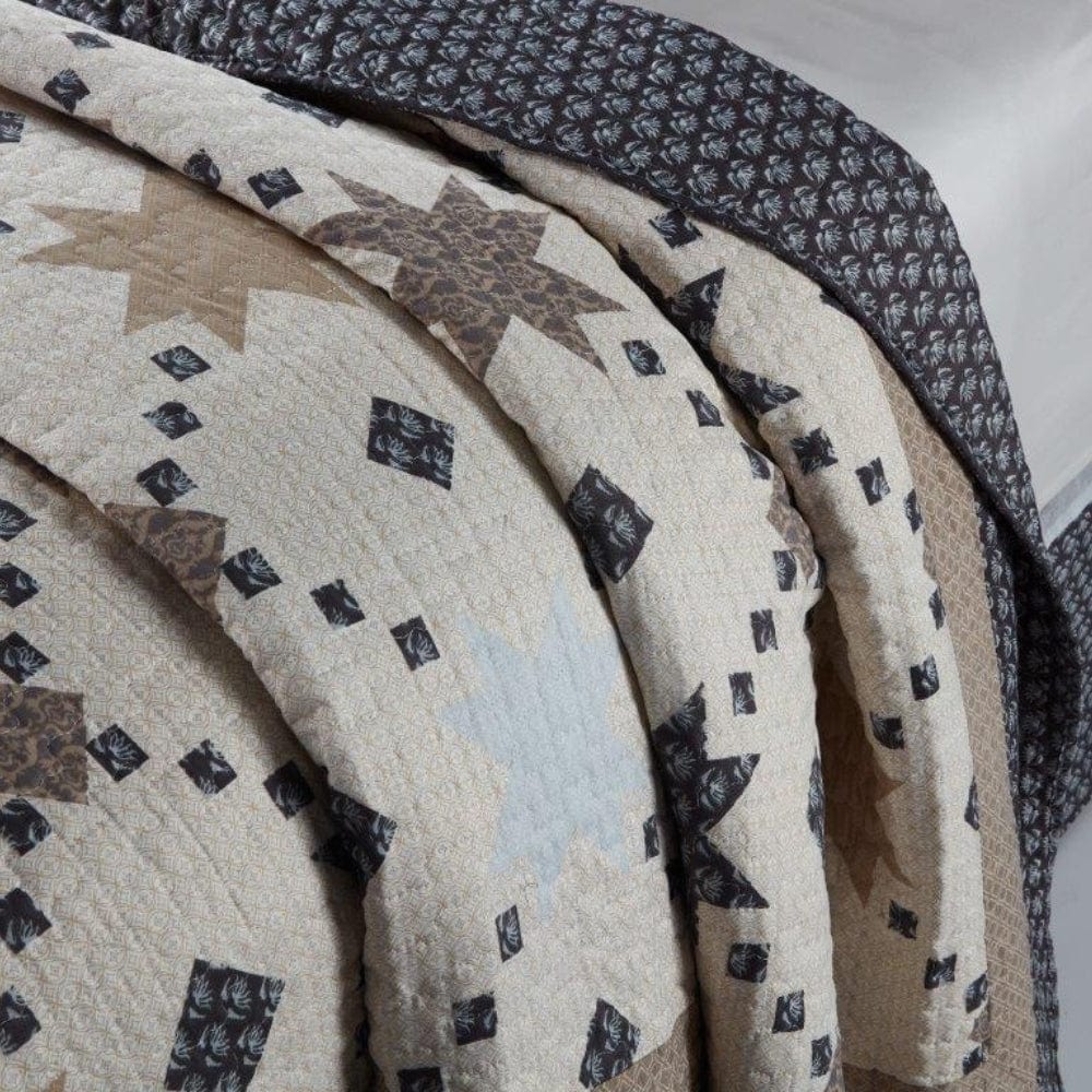 Transform your space with the Constellation Quilt Set, featuring a stunning design of gray and beige stars on a white background.