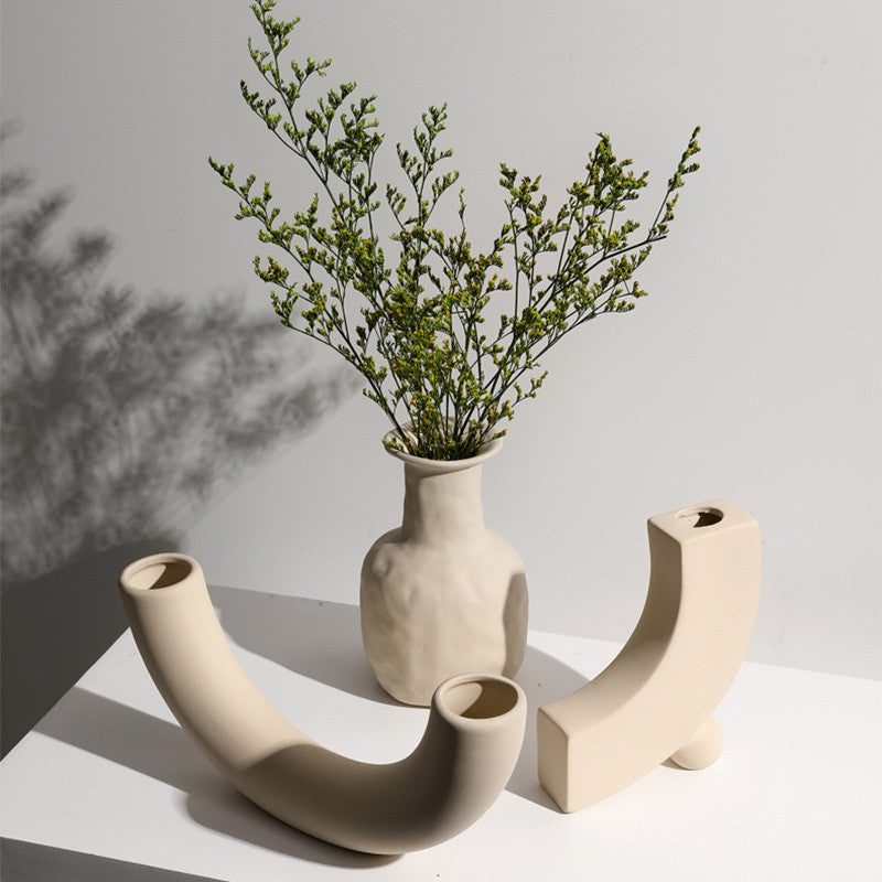 Set of taupe ceramic vases with matching candle holders, modern minimalist decor.