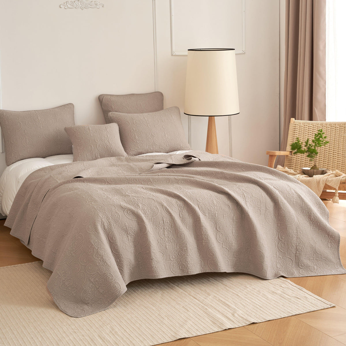 Taupe beige matelasse quilted bedspread set on bed.