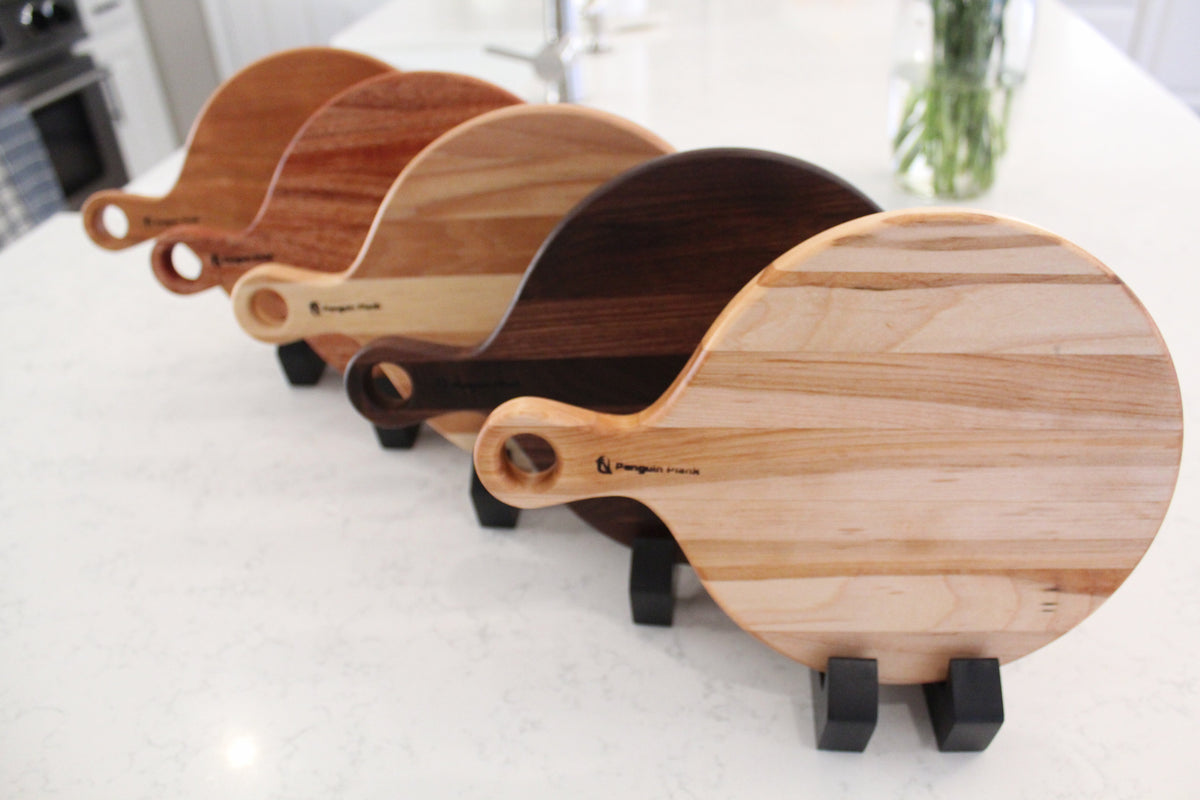 Round cherry wood cheese board with charcuterie and appetizers.