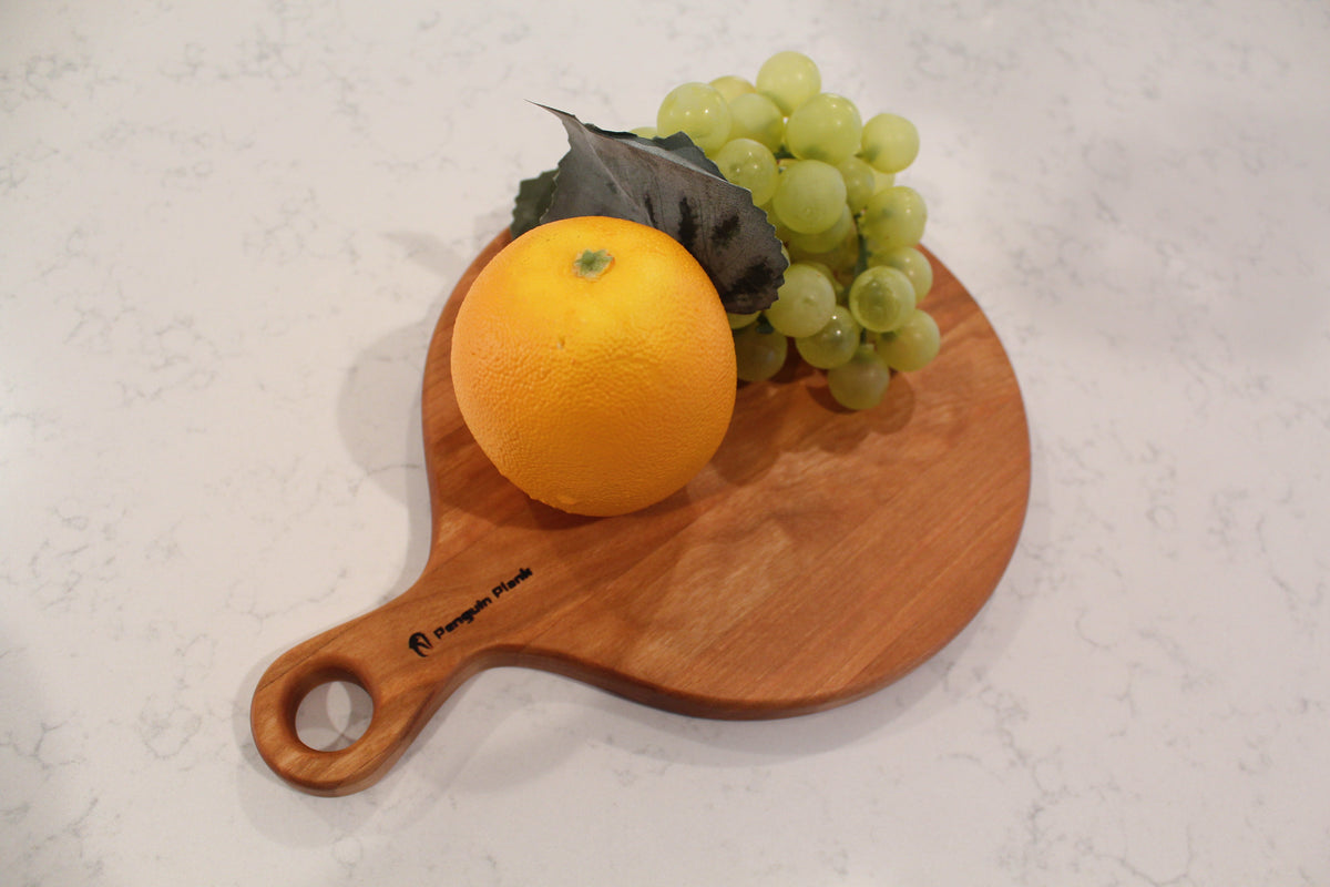 Round cherry wood cheese board serving platter for charcuterie and appetizers.
