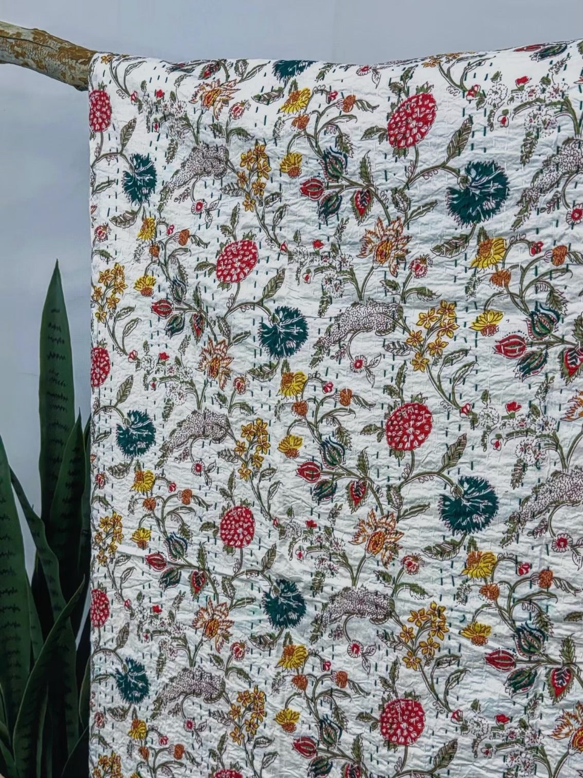 Close-up of a cotton bedspread with a hand-block printed wildflower field design.