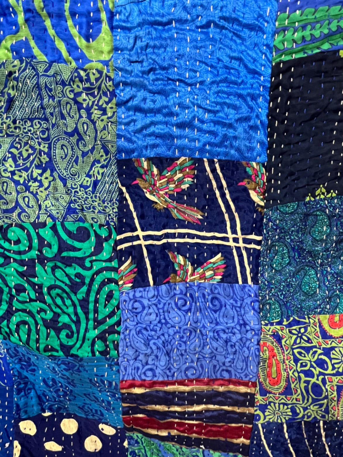 Pink patchwork silk Kantha quilt, hand-stitched by Indian artisans.