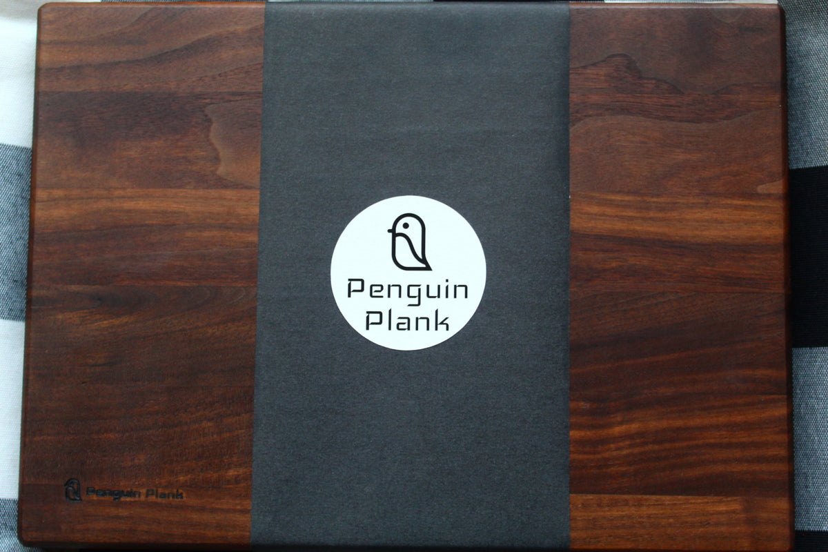 Walnut picnic cheese board with penguin design, perfect for outdoor dining.