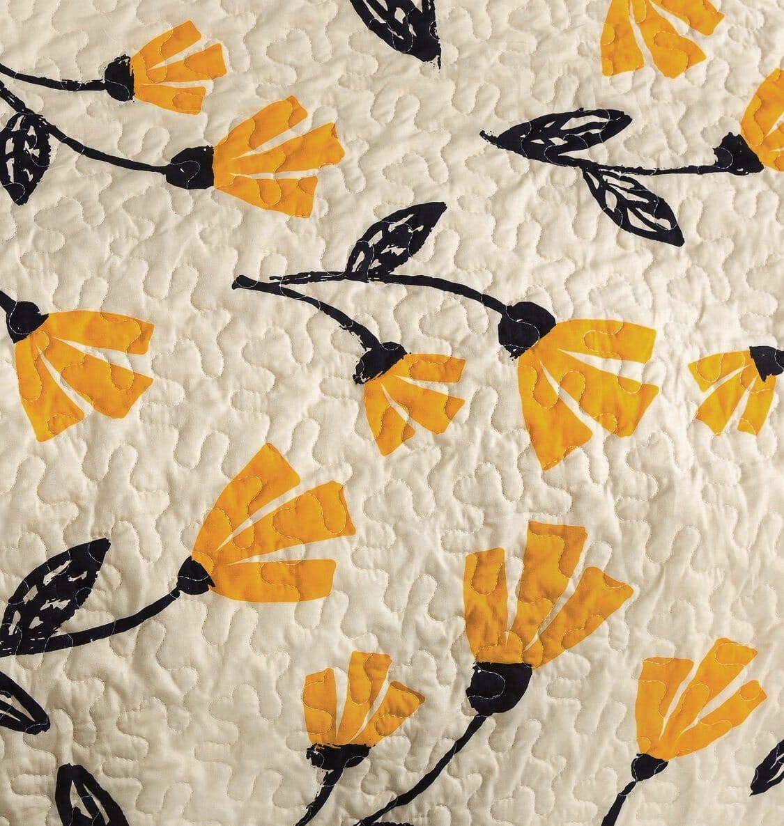 Yellow floral scalloped bedspread set on ivory cream background.