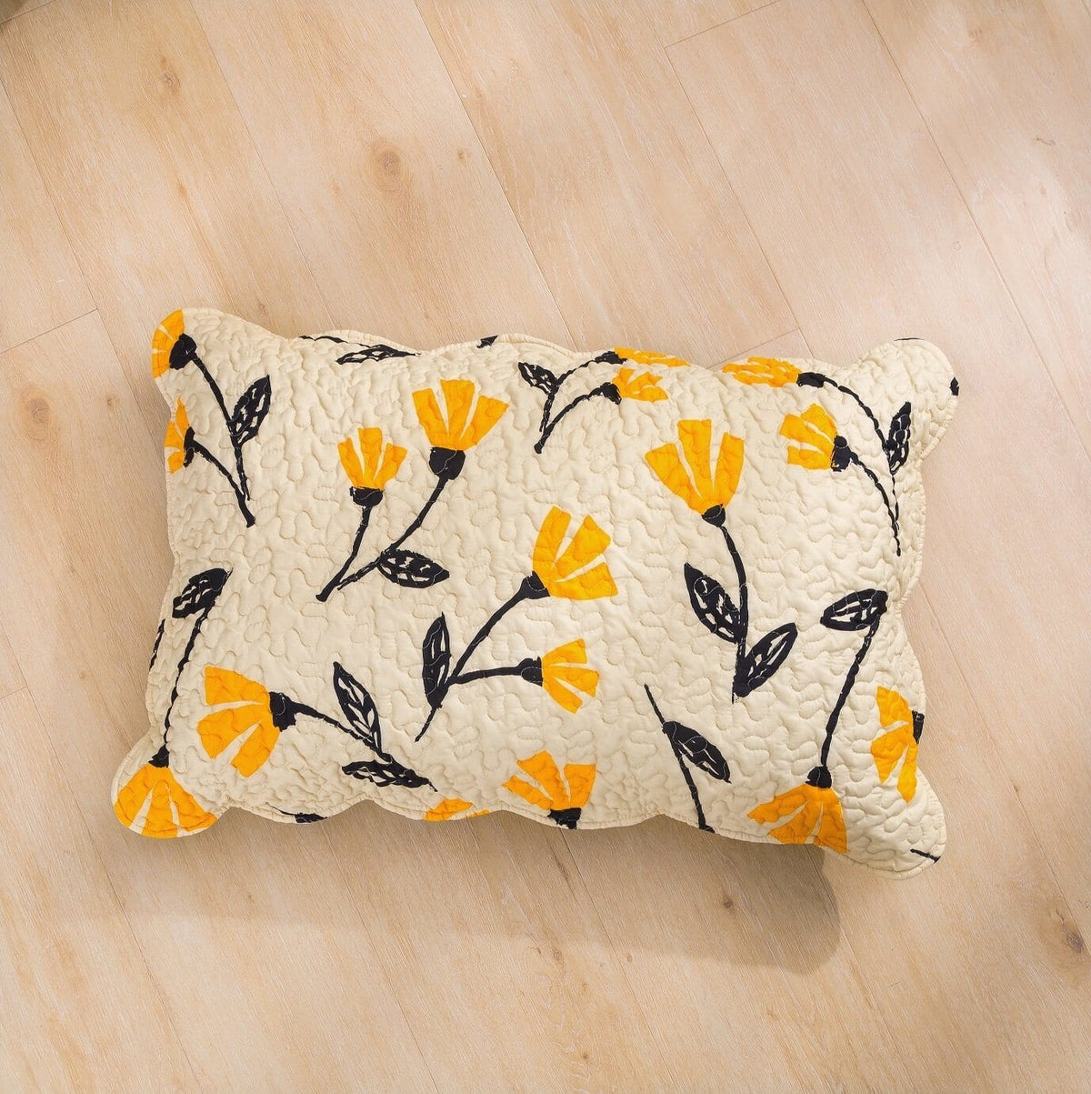 Yellow floral scalloped bedspread set on ivory cream background.