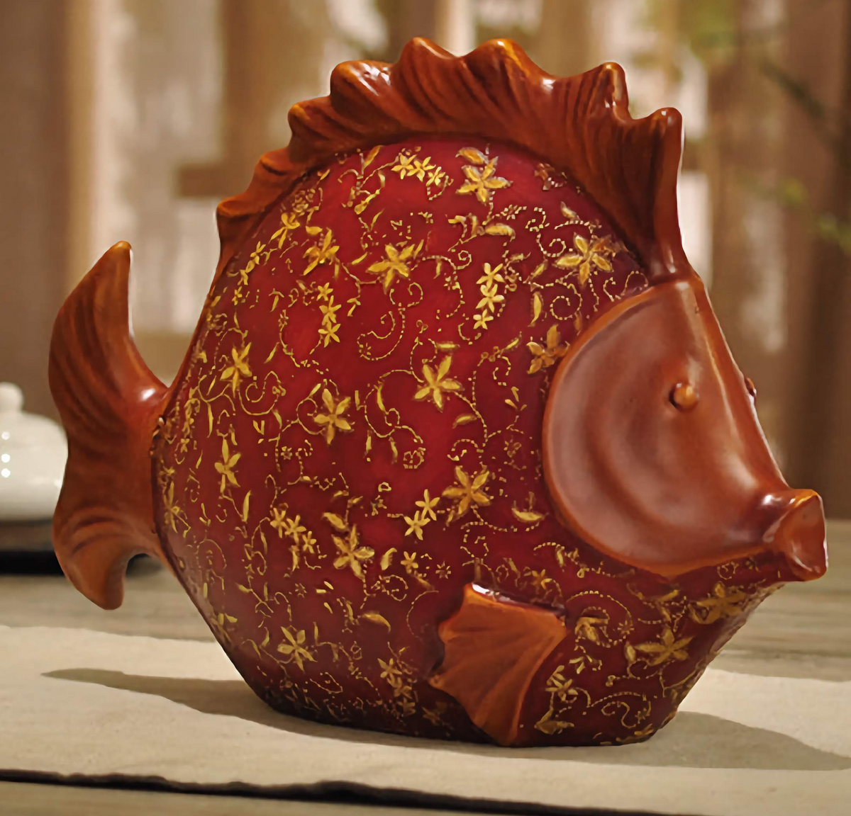 Large red resin fish sculpture hand-painted with gold patterns.