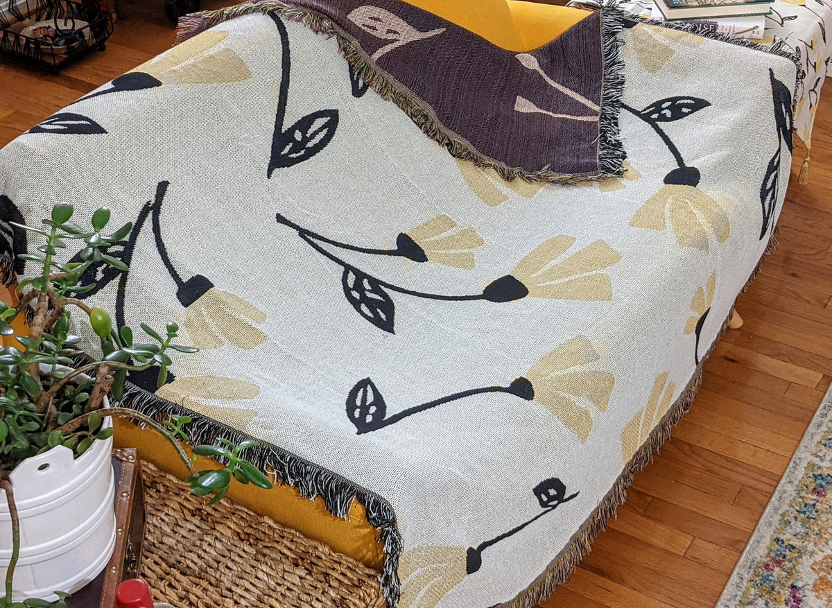 Yellow floral botanical throw blanket with golden floral tapestry design.