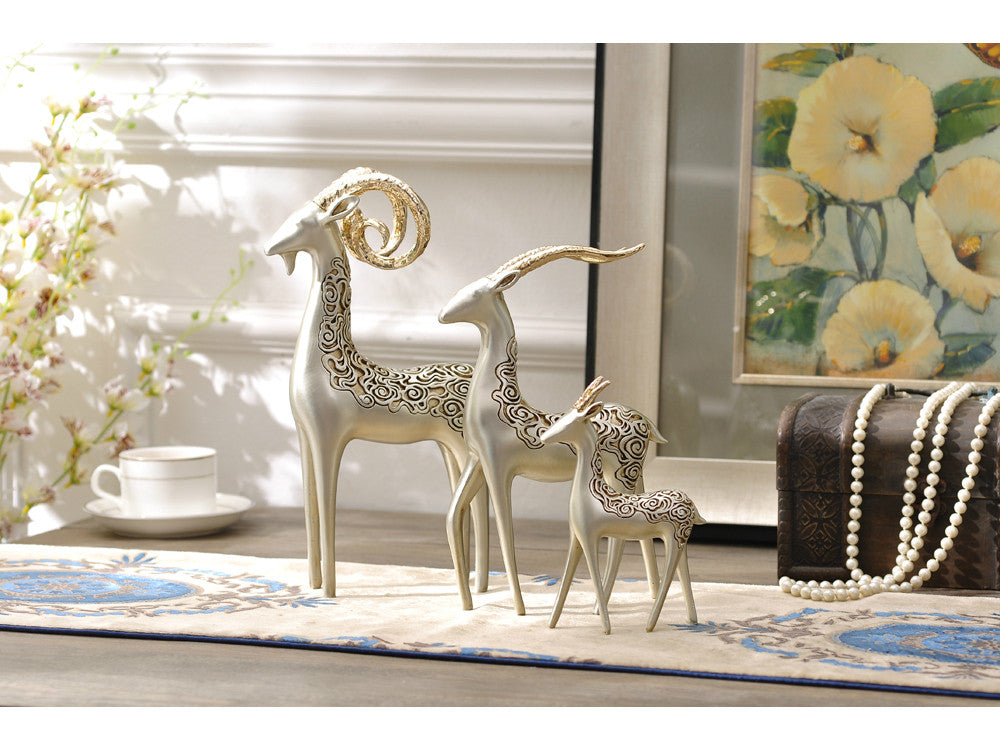 Three resin bighorn sheep sculptures with golden horns, family decor.