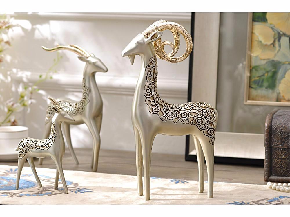 Three bighorn sheep sculptures with golden horns, resin table decor.