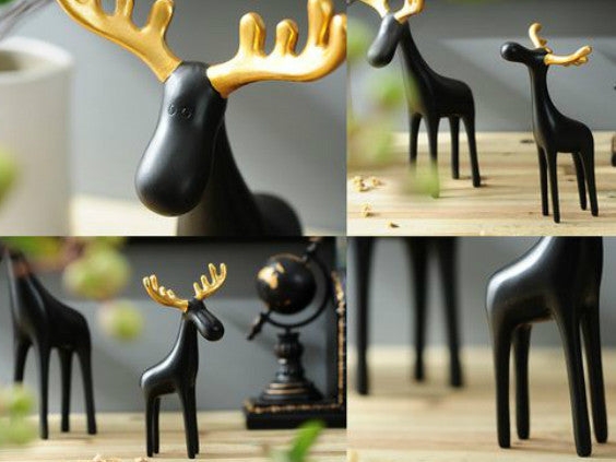 Three black reindeer sculptures with gold antlers, resin table decor.