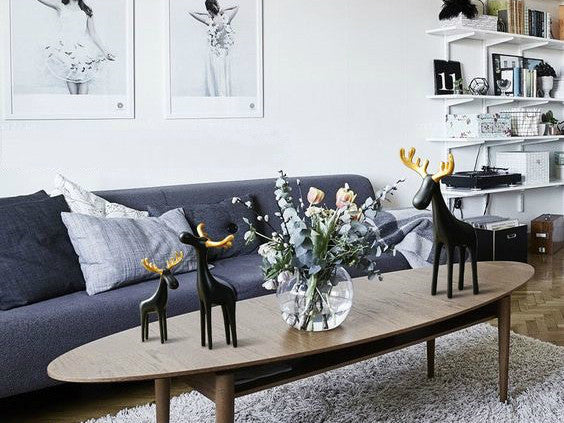 Three black reindeer sculptures with gold antlers, resin table decor.