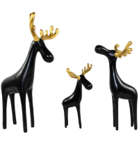 Three black resin reindeer sculptures with gold antlers, a family of three table decor.