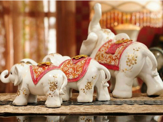 Three red jewel-covered Maharaja elephant sculptures.