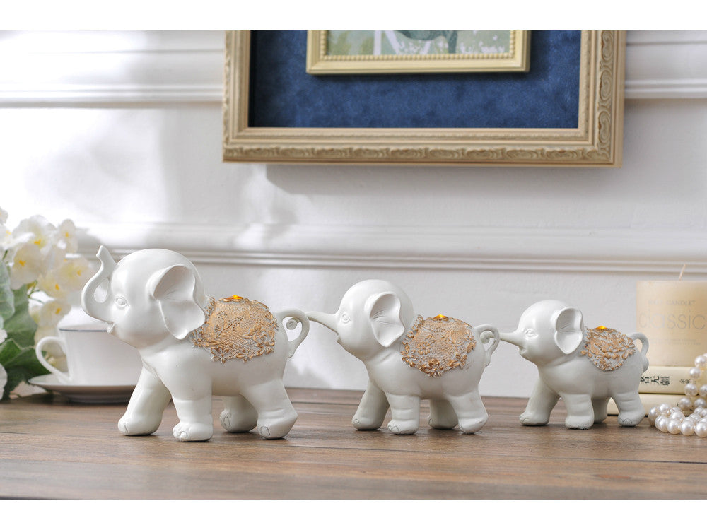 White resin sculpture of a family of three elephants for home decor.