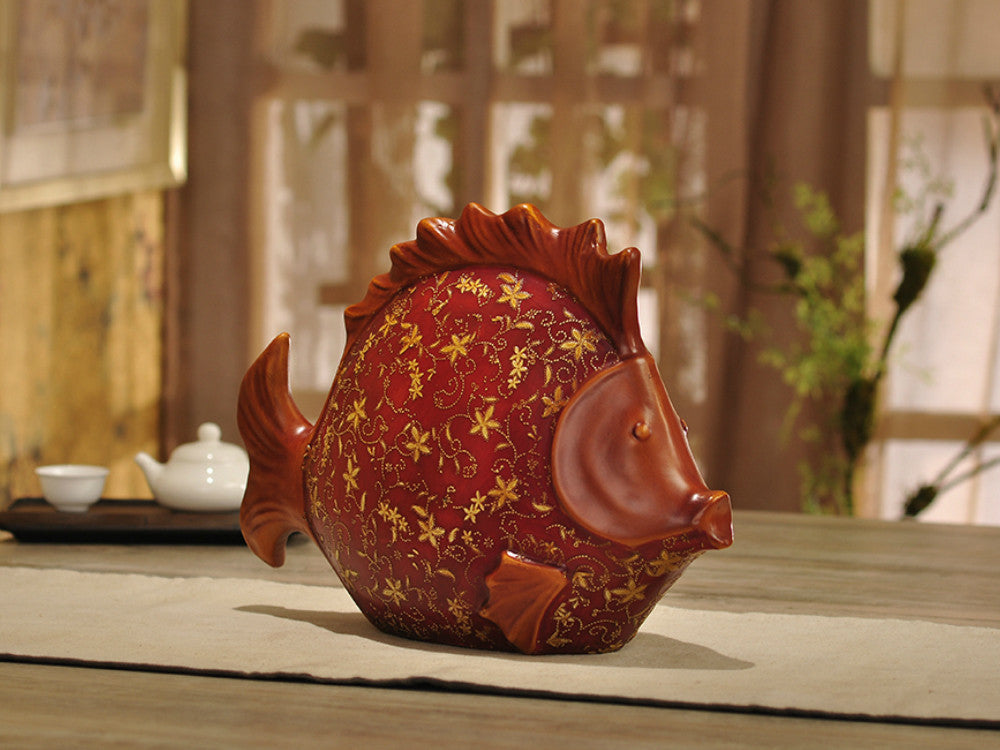 Large red resin fish sculpture hand-painted with gold patterns