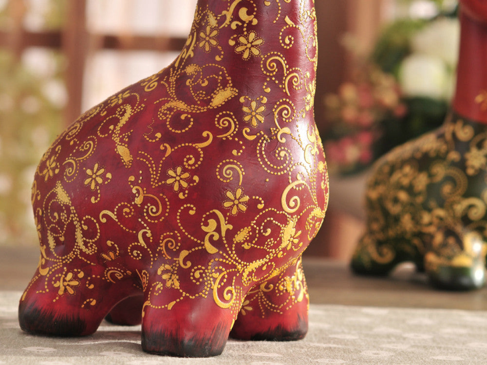 Hand-painted resin sculpture set of a colorful giraffe family.