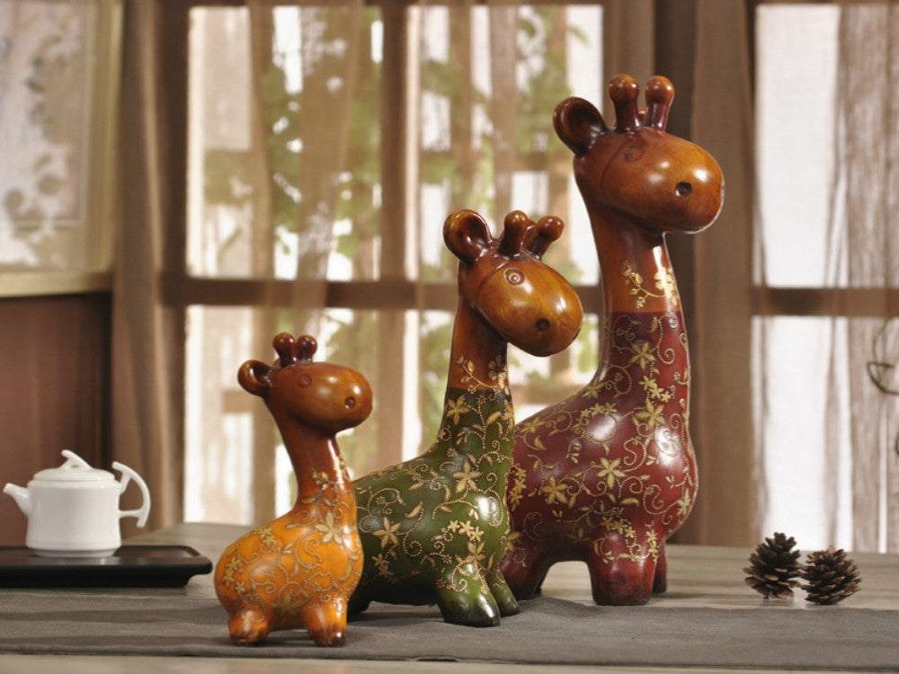 Hand-painted resin sculpture set of a colorful giraffe family.