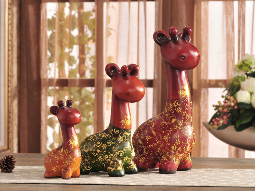 Hand-painted resin sculpture set of a colorful giraffe family.