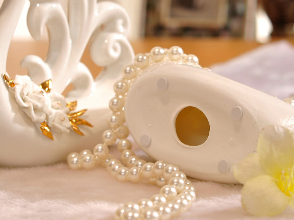 White porcelain swans with decorative wings for table decor