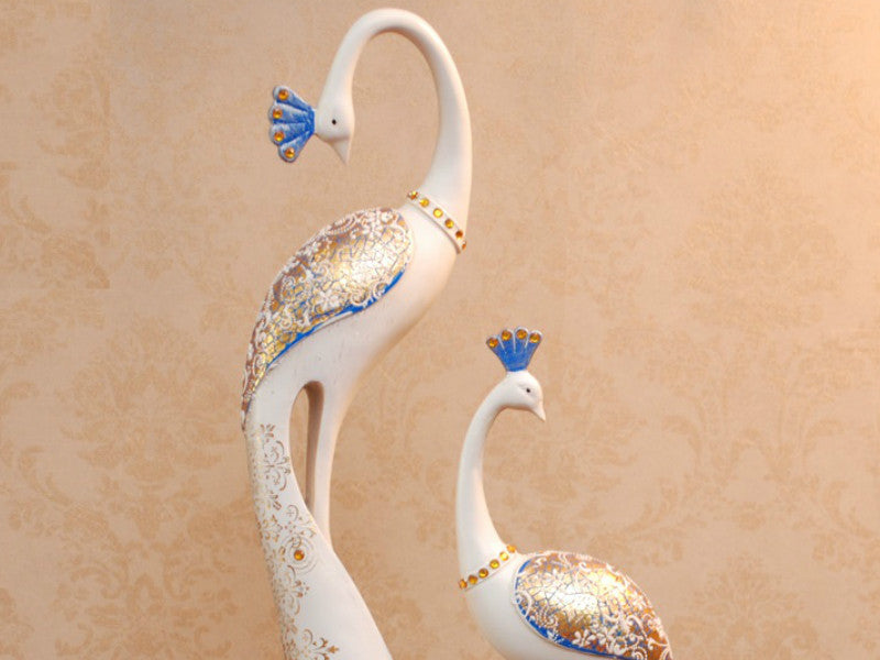 Pair of hand-painted white and blue peacock sculptures for table decor.