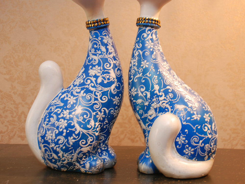 Two hand-painted blue resin cat sculptures, happy expression, tabletop decor.