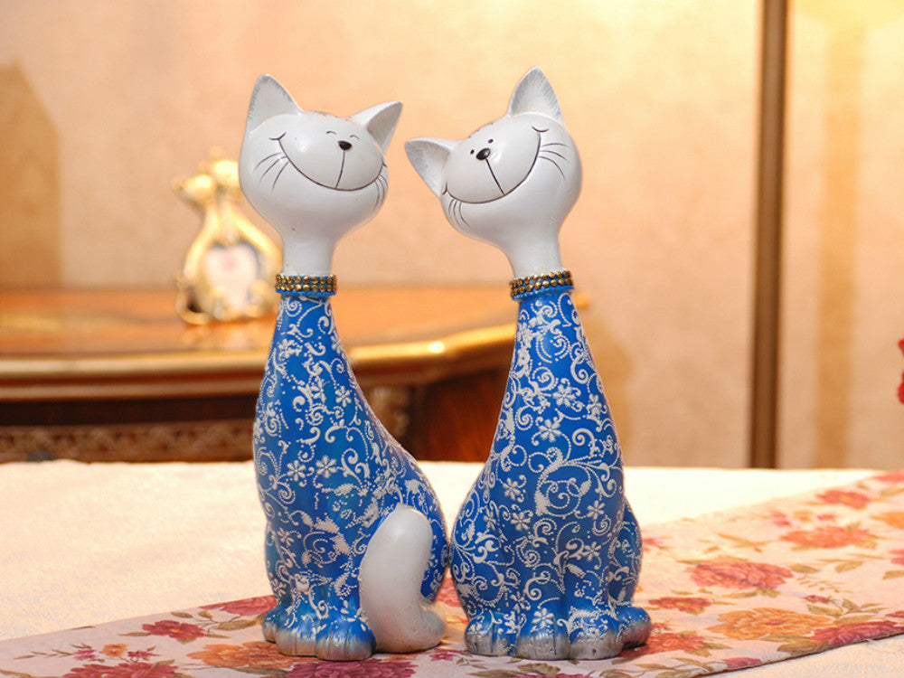 Two hand-painted blue resin cat sculptures, happy expression, tabletop decor.