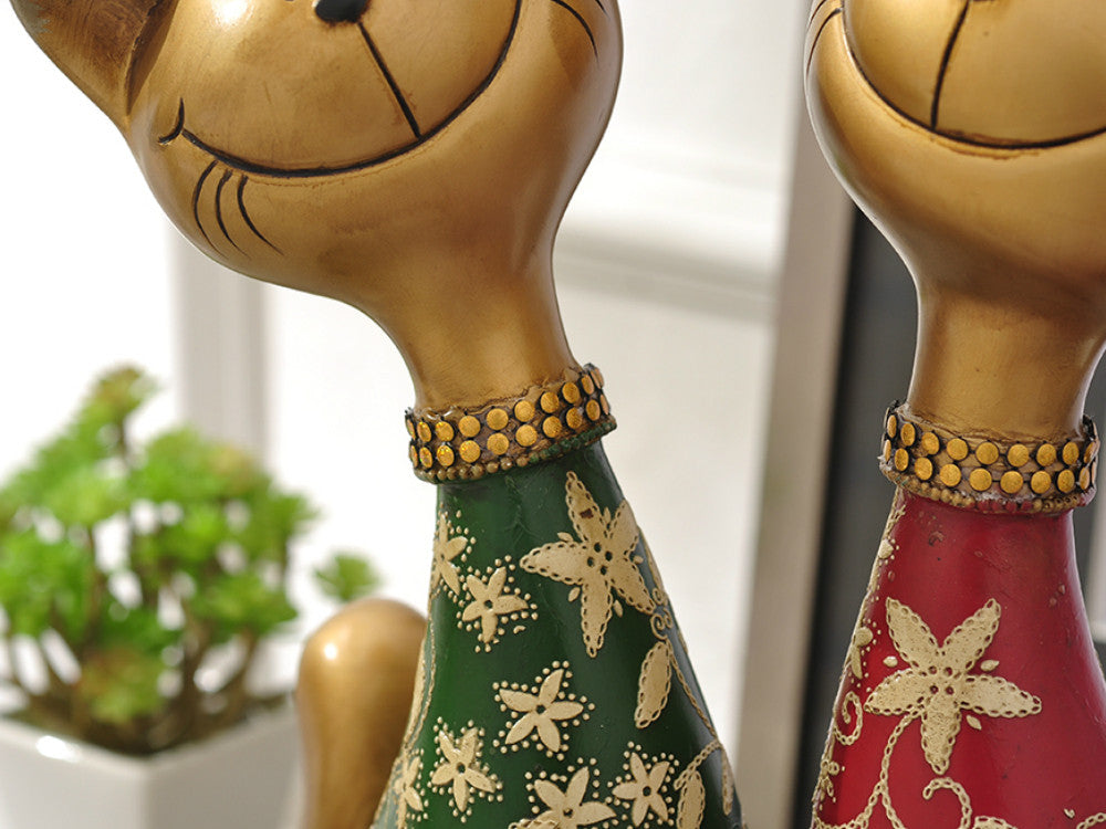 Red and green resin happy cat sculptures for mantelpiece or table decor.