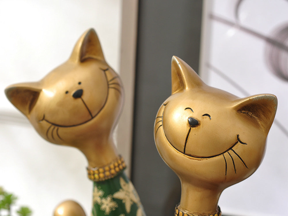 Red and green happy cat resin sculptures for mantelpiece or table decor.