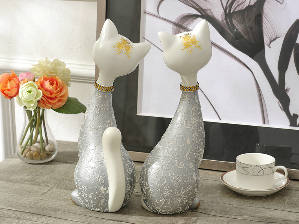 Pair of silver finish resin cat statues for table decor.