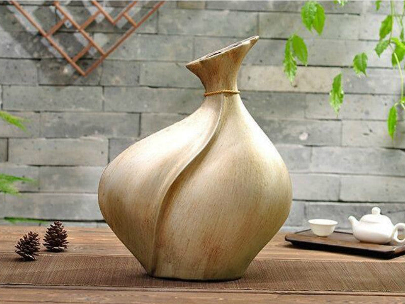 Antique brown resin broad vase with floral decor detail.