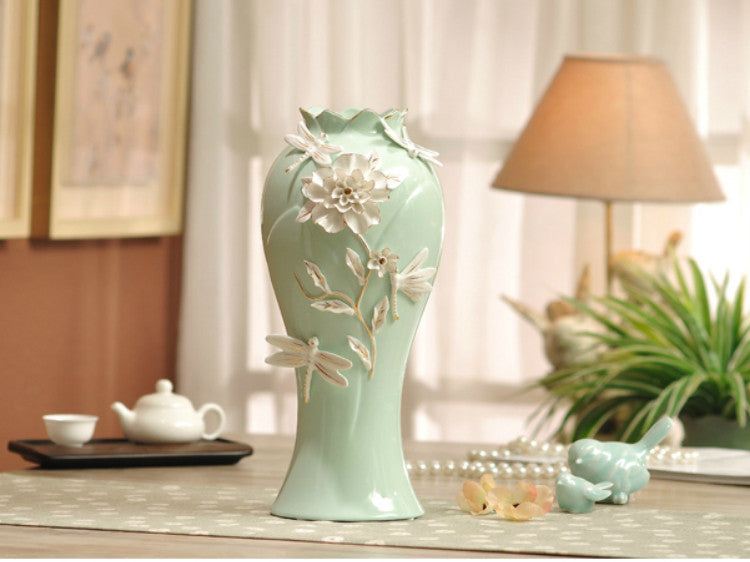 Aqua green porcelain vase with delicate pinched white flowers, elegant floral decor.
