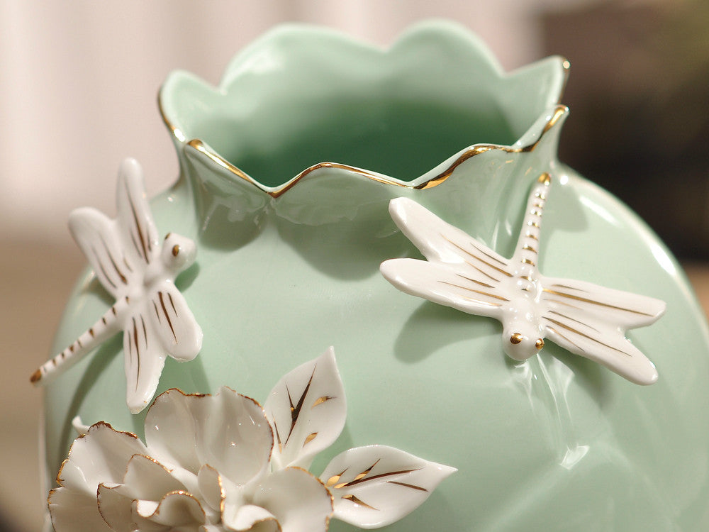 Aqua green porcelain vase with delicate pinched white flowers, elegant floral decor.