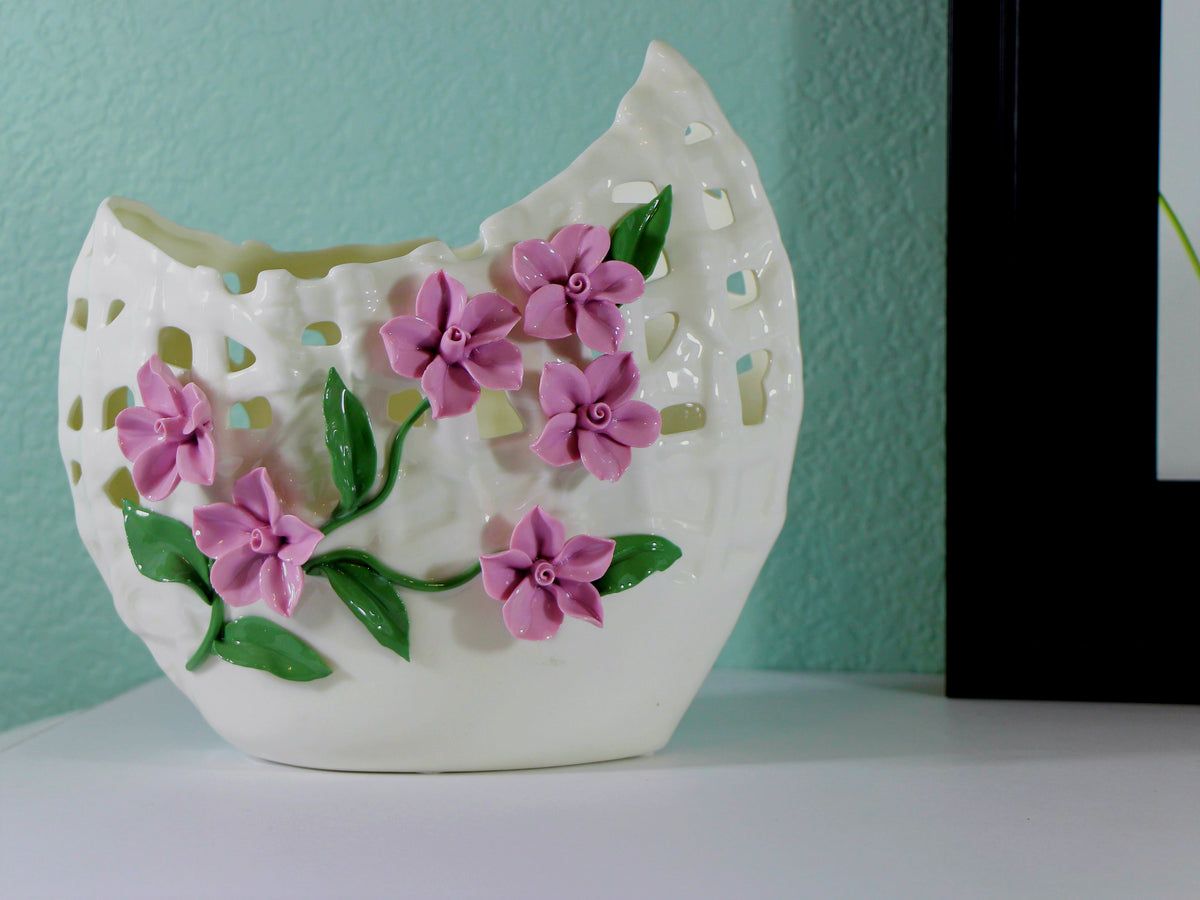 White porcelain vase with delicate pinched purple flowers.