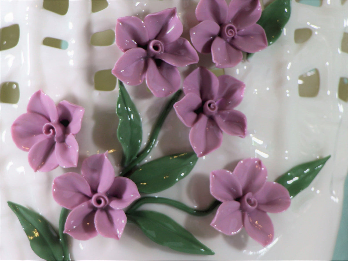 White porcelain vase with pinched purple flowers