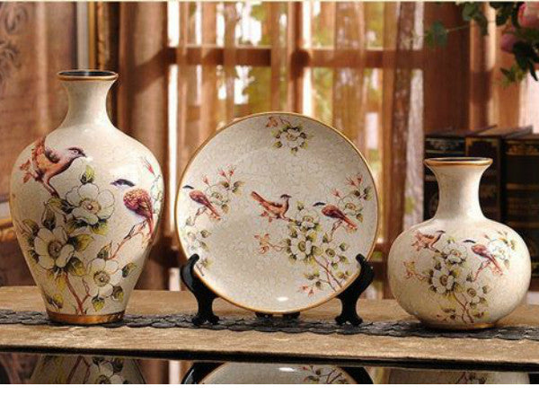 Three hand-painted ceramic vases with floral and bird designs.