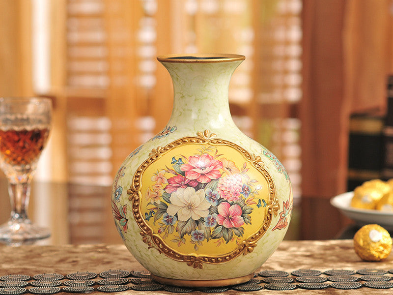 Three yellow vintage ceramic vases with gold bands and floral designs.