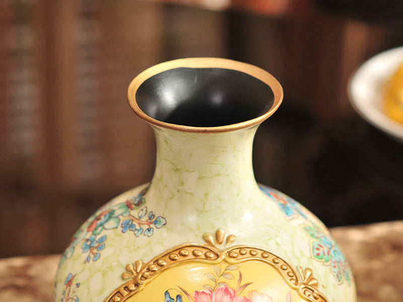 Three vintage yellow ceramic vases with gold bands and floral designs.