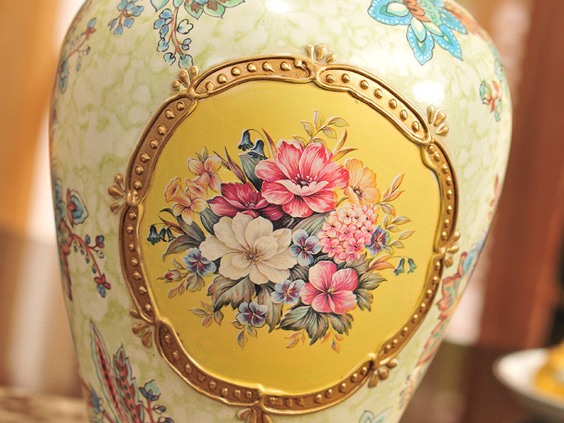 Three yellow vintage ceramic vases with gold bands and floral design.