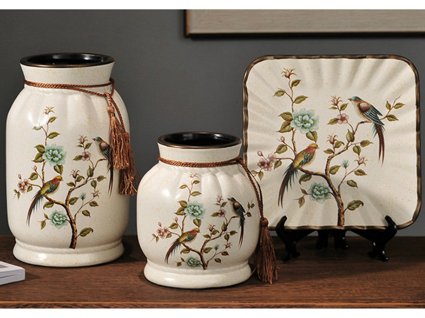 Three hand-painted cream floral ceramic vases with green bird accents.
