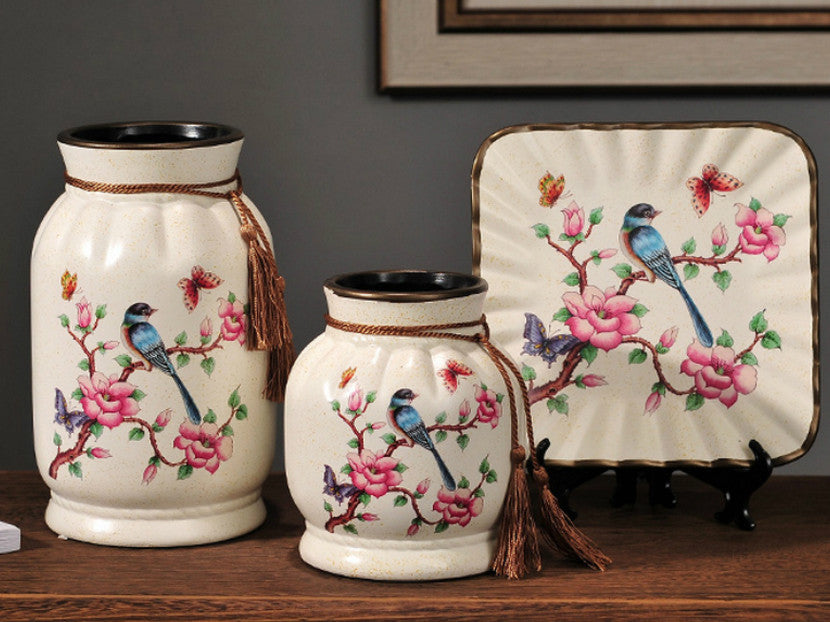 Three blue ceramic vases with hand-painted birds in a meadow design.