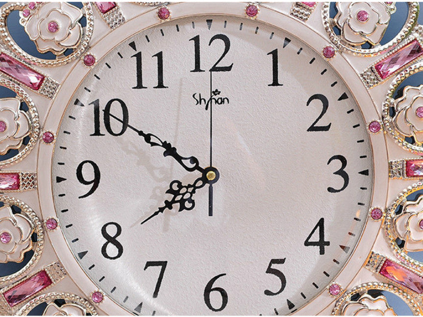 Metallic gold pendulum wall clock with pink stone accents