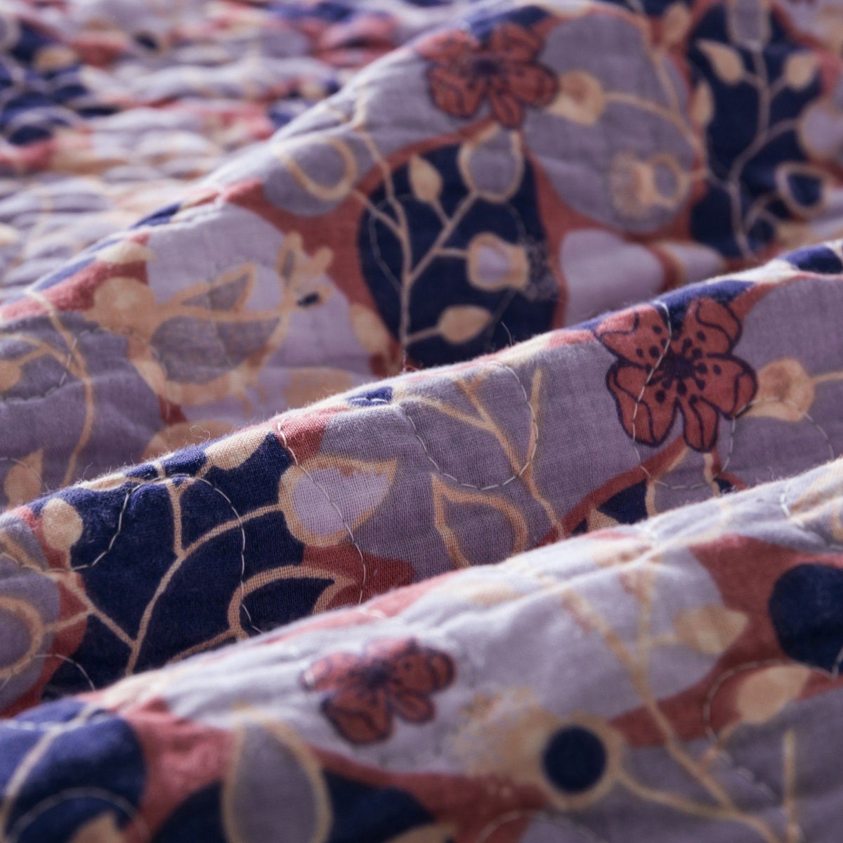 Peachy pink, plum purple floral patchwork quilted bedspread set detail.