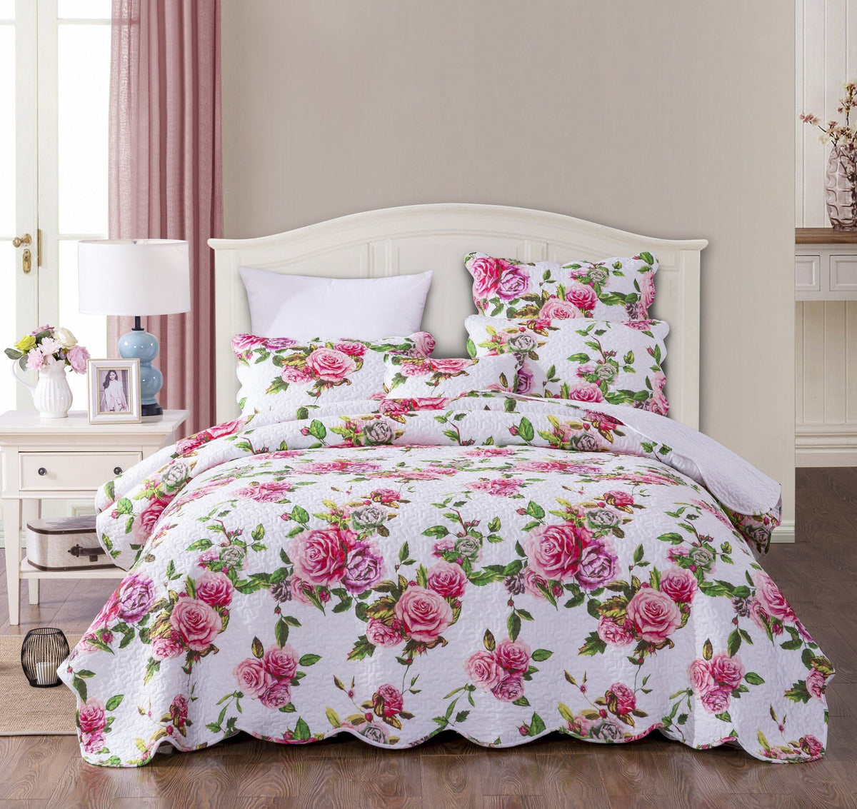 Pink floral quilted bedspread set with scalloped edges and roses.