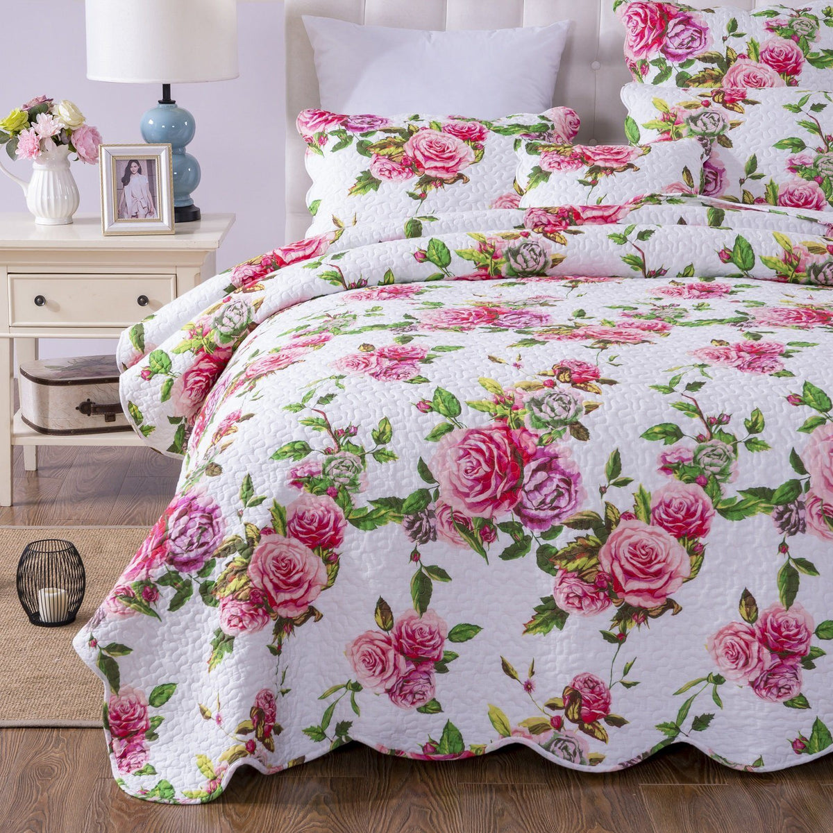 Pink floral quilted bedspread with scalloped edges and matching shams.