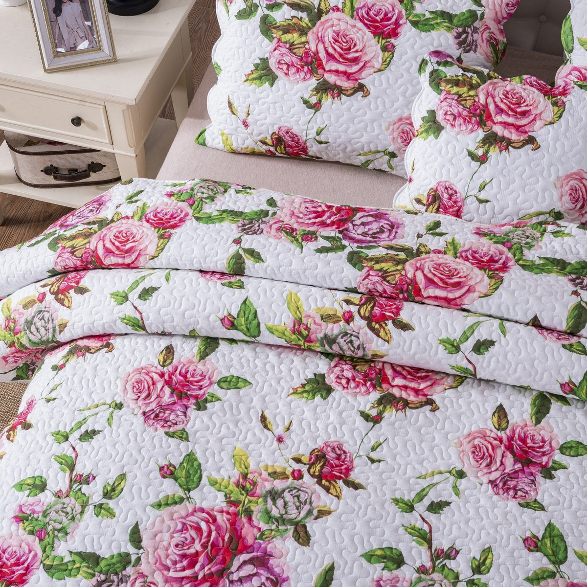 Pink floral quilted bedspread set with scalloped edges and rose pattern.