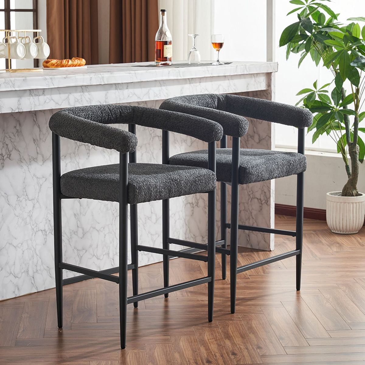 Two boucle fabric upholstered counter height bar stools in a modern design.