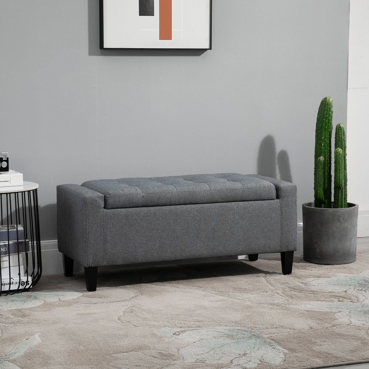 Gray linen upholstered storage ottoman with lift top.