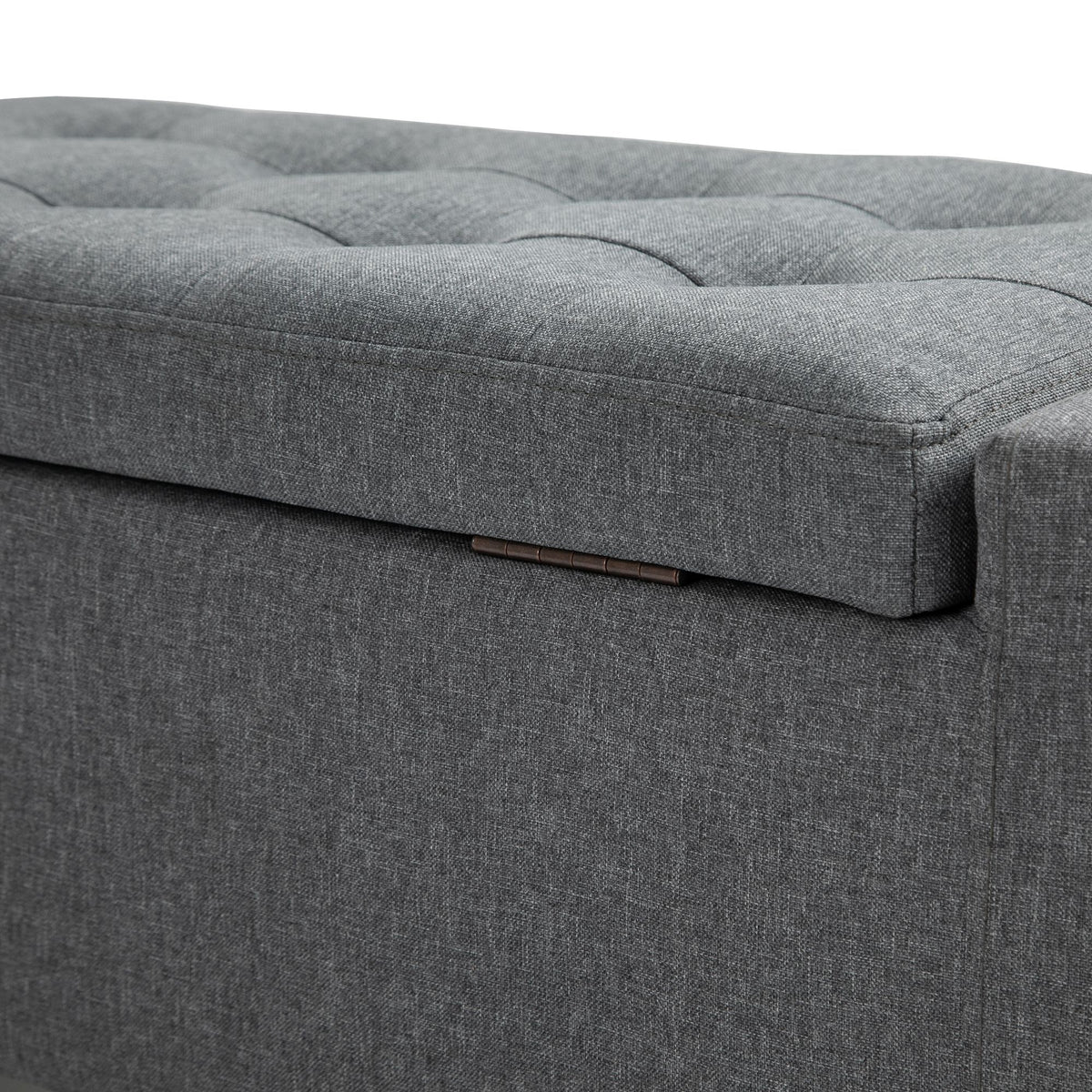 Gray linen upholstered storage ottoman with lift-top, doubles as footstool.