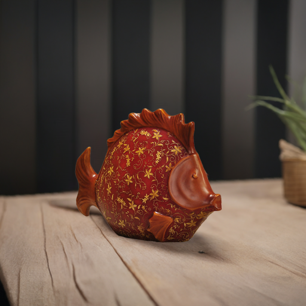 Large red resin fish sculpture with hand-painted gold patterns.